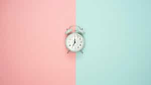 Horloge sur fond pastel indiquant le temps de la tenue d'une coloration
