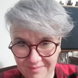 Femme aux cheveux blanc-gris avec lunettes de vue rouges